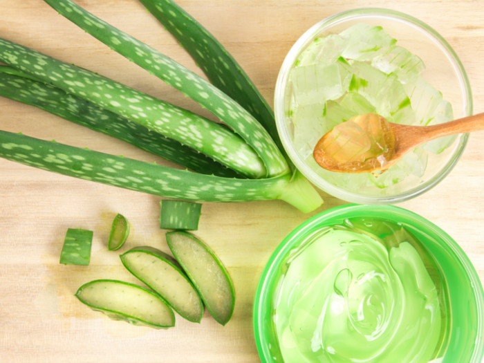 In the picture, a clear, soothing aloe vera gel is shown in a small, transparent container placed on a natural surface. Around the container are fresh, green aloe vera leaves, one of which has been cut open to reveal the thick, clear gel inside. The scene appears clean, fresh, and organic, highlighting the natural and pure qualities of aloe Vera gel.



